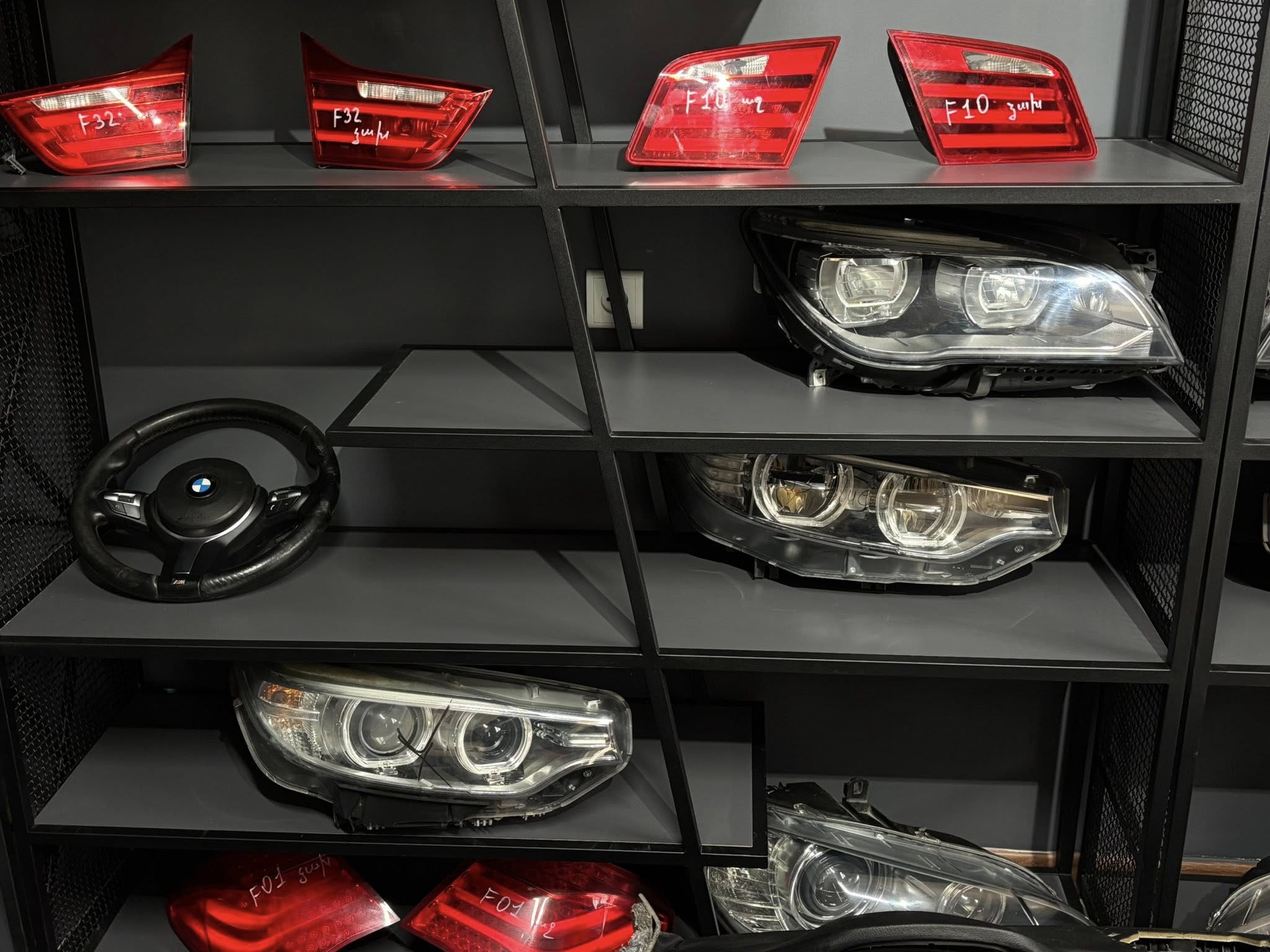 BMW headlights and steering wheels on shelves